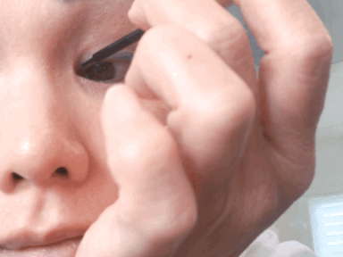 Woman applying magnetic eyeliner on eye.